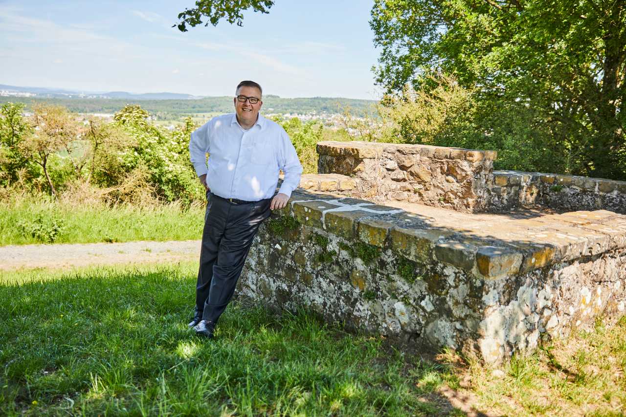 Andreas Ruck an einer historischen Mauer mit Blick über Pohlheim.