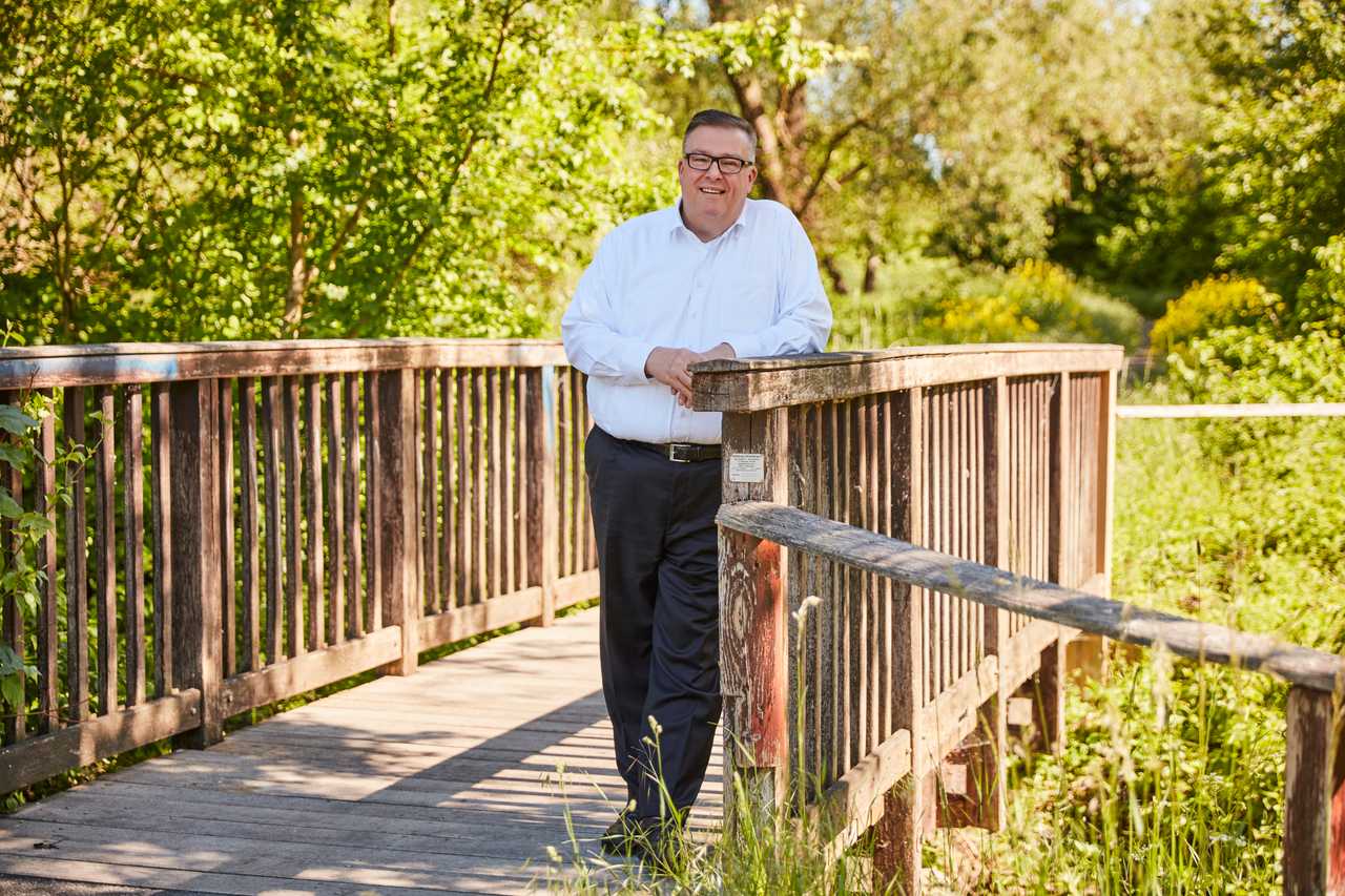 Andreas Ruck an einer Holzbrücke im Grünen.